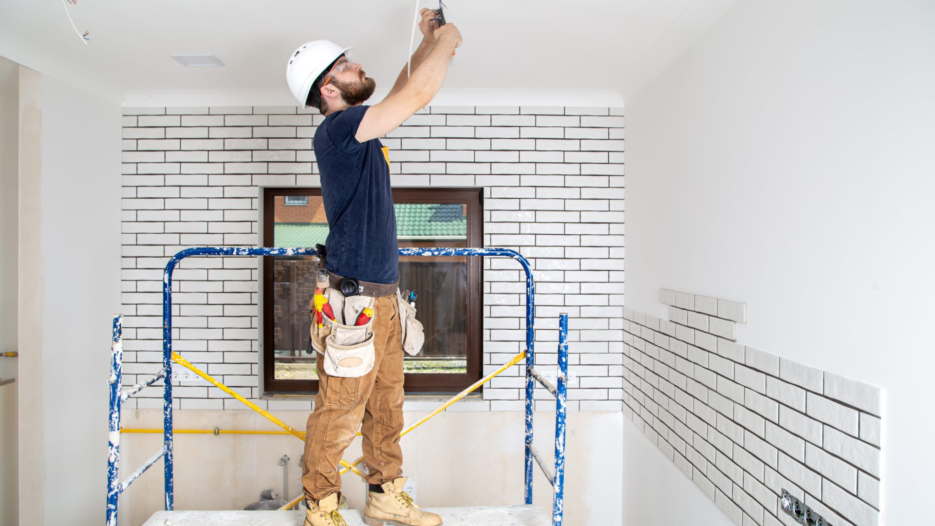 Professional in overalls with tools on the background of the repair site. Home renovation concept.
